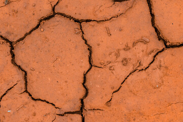 Barren, cracked and parched orange soil. Global warming concept. Textured background.