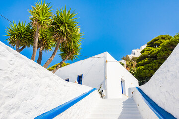 White steps to traditional Greek restaurant with tropical garden in Plaka village, Milos island, Cyclades, Greece