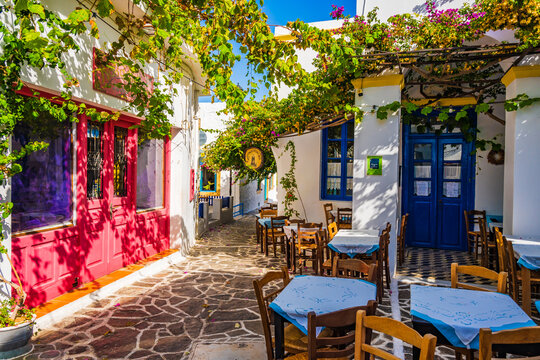PLAKA VILLAGE, MILOS ISLAND - SEP 25, 2023: Chairs with tables in traditional Greek restaurant tavern in Plaka village, Milos island, Cyclades, Greece.