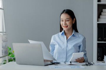 Asian woman sitting in startup company office, businesswoman, executive and investor in business and stocks, management of young people, new concept. Start-up company management concepts.