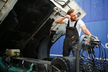 Fototapeta premium Man in uniform. Truck repair. Car malfunction