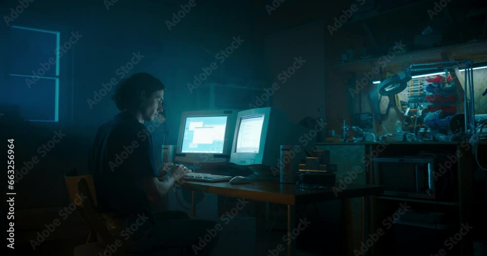 Leinwandbilder caucasian male programmer using old desktop computer with two monitors in retro garage late at night