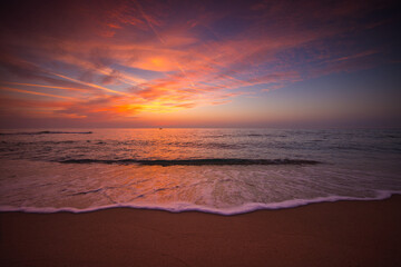 Fototapeta na wymiar Beautiful sunrise over the sea shore and beach sand