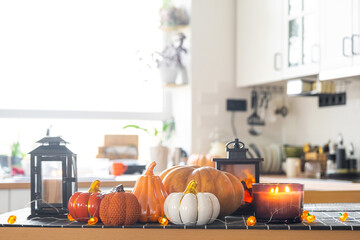 Decor of white classic kitchen with pumpkins, garlands, latern for Halloween and harvest with...