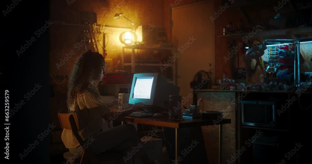 Poster Hispanic Female Web Designer Using Old Desktop Computer In Retro Garage Late At Night. Focused Internet Enthusiast Writing Code At Home. Programming Successful Online Forum Website In Nineties.