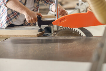 Close up of carpenter cutting wooden board at sawmill carpentry manufacturing . Sawing machine