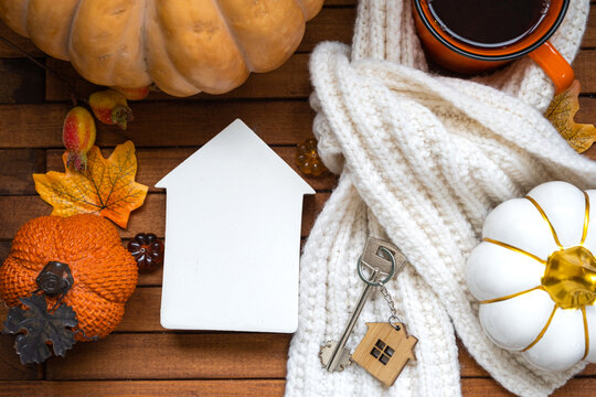 Cozy layout home mock up on a wooden background of slats with pumpkins, autumn leaves, a house and keys - autumn mood, Halloween, housing, relocation, mortgage, insurance.