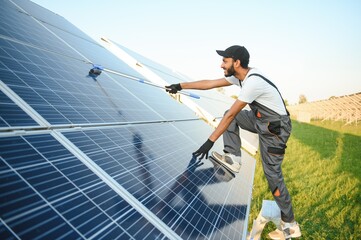 Indian worker cleaning solar panels.