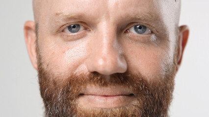 Fototapeta premium Handsome person look at camera close up. Young adult man face portrait. Stylish 30s guy on isolated white background. Attractive male model. Modern millennial people. Brutal bearded style. Barber shop