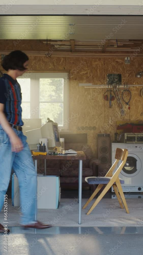Poster vertical screen: caucasian man opening garage door and sitting behind old desktop computer in retro 