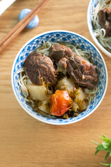 Beef noodle soup. Taiwanese famous food in a bowl on wooden table.