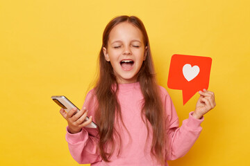 Excited amazed little girl sharing popular content on social media showing blogger heart like icon...