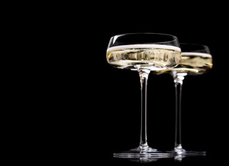 Two champagne glasses on a black