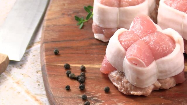 paupiettes de viande cru, en gros plan, sur une planche &agrave; d&eacute;couper	