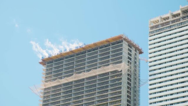 Smoke on the roof of multi storey buildings on city construction site. Building skyscraper houses, industrial development, construction site engineering