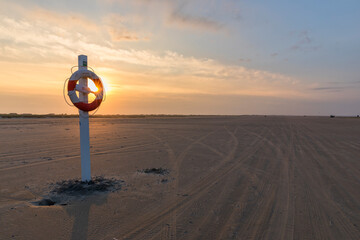 Life buoy at the beach of Fanø in sunrise - obrazy, fototapety, plakaty