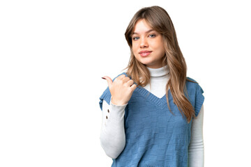 Young girl over isolated chroma key background pointing to the side to present a product