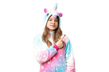 Young girl with unicorn pajamas over isolated chroma key background pointing to the side to present a product