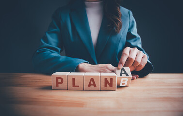 Businesswoman hand flipping wooden blocks cubes text with PLAN A change to PLAN B on table. Strategy, change, alternative, analysis, marketing, project and crisis concepts. - obrazy, fototapety, plakaty