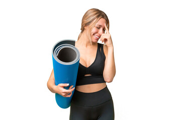 Blonde sport woman going to yoga classes while holding a mat over isolated chroma key background...