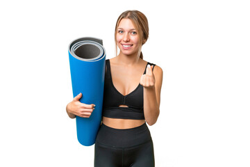 Blonde sport woman going to yoga classes while holding a mat over isolated chroma key background...