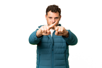 Brazilian man over isolated chroma key background making stop gesture with her hand to stop an act