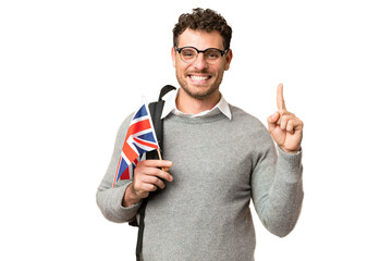Brazilian man holding an United Kingdom flag over isolated chroma key background showing and...