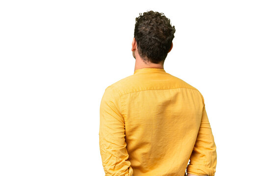 Brazilian man over isolated chroma key background in back position and looking back