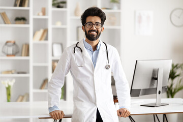 Indian Healthcare Worker Smiling, Posing at Workplace - obrazy, fototapety, plakaty