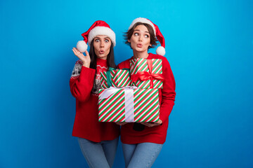 Photo of impressed funky ladies santa helpers dressed print sweaters choosing xmas presents...