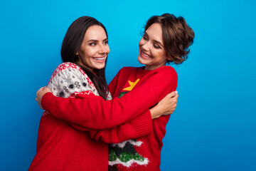 Photo of two girls warm cuddling on christmas party event isolated blue color background