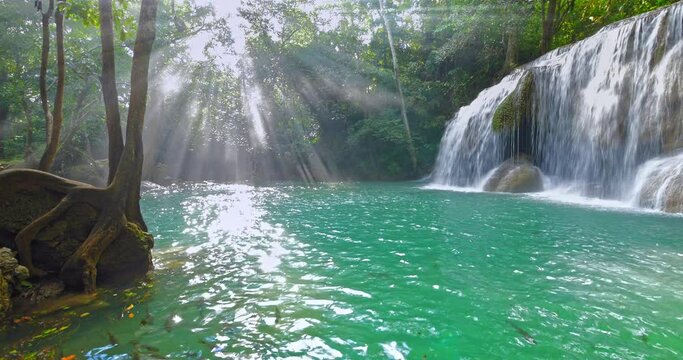 Nature paradise. Sunshine on waterfall with blue water lake. Sun rays