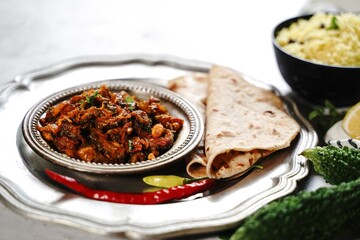 Bitter gourd curry - karela subji served with rice and roti, selective focus