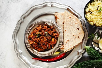 Bitter gourd curry - karela subji served with rice and roti, selective focus
