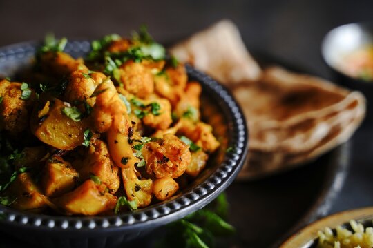 Homemade aloo Gobi - Indian vegetarian curry made with potatoes and cauliflower served with rice and roti