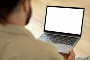 Man Using Laptop Computer With Blank White Screen