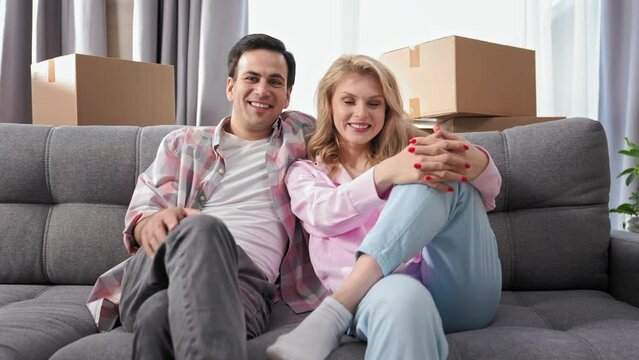 Happy family sit on sofa home portrait. Love couple move into house. Smile people look camera. Fun girl jump couch. Joy adult buy real estate concept. Funny guy rent flat. Romantic hug. Man have rest.