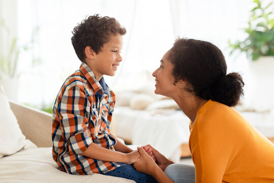 Joyful mother and son engaging in chat talking at home