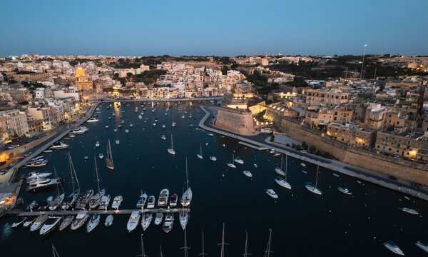 Aerial view of many sailboat docked at the harbour in La Valletta downtown at sunset in Malta.