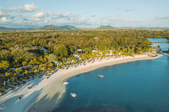 Aerial view of a paradise beach with parasols along the coastline, Ilot Lievres, Flacq, Mauritius.