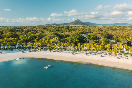 Aerial view of a paradise beach with parasols along the coastline, Ilot Lievres, Flacq, Mauritius.