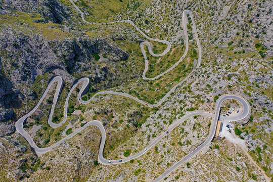 Aerial view of a twisting road down the mountain near a scenic spot called Nus de sa Corbata in Balearic Islands, Spain.