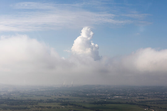 Aerial view of Morning Fog Blending With Smoke Stacks On Horizon, Victoria, Australia.