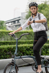 Obraz premium Eco friendly, businesswoman ride bicycle in urban to reduce carbon footprint. Beautiful woman environment preservation person commuting with bicycling. Cycling, alternative transport for clean energy.