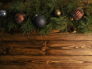 Festive traditional Christmas baubles, blue, brown balls, fir tree branches, on shabby old rustic wooden table. Christmas background, New Year, winter holiday concept. Copy space, top view, flat lay