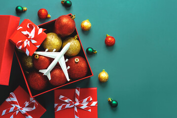 Christmas concept background. Top view of christmas gift box, christmas balls and plane. Christmas...