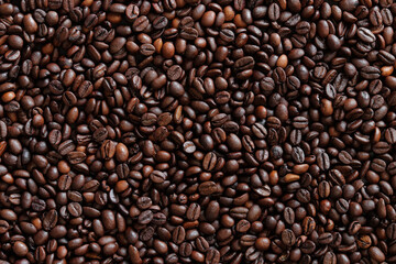 Top view of background representing halves of dark brown coffee beans. Roasted coffee beans, copy space