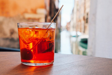 A glass of refreshing Aperol Spritz cocktail served on the deck bar in Venice. Traditional italian...