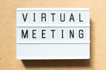 Lightbox with word virtual meeting on wood background