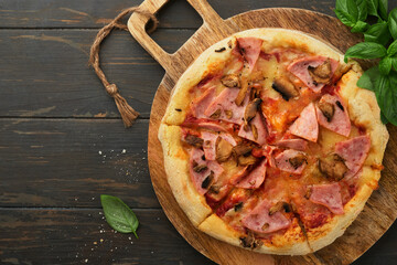 Pizza. Traditional Bacon pizza with ham, mushrooms, pickled cucumber and cheese and cooking ingredients tomatoes basil on wooden table backgrounds. Italian Traditional food. Top view. Mock up.